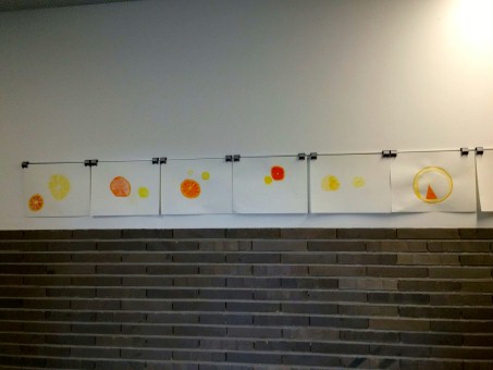 An der Wand hängen Bilder zum Thema Druckverfahren mit Zitrusfrüchten