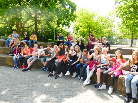 Schülerinnen und Schüler der Europaschule und der Ernst-Jandl-Schule sitzen gemeinsam auf einer Mauer