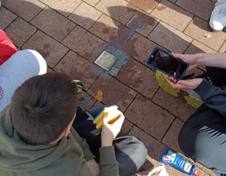 Schüler reinigen Stolpersteine und filmen dabei