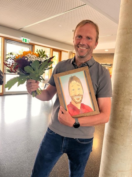Lehrer freut sich mit einem Bild in der Hand