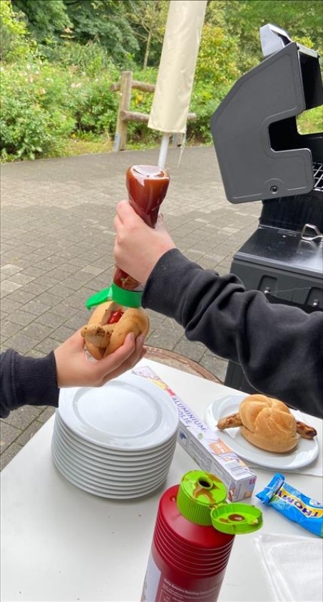 Bratwurst mit Brötchen wird Ketchup drauf gemacht