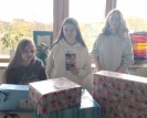 3 Schülerinnen die vor Geschenken stehen