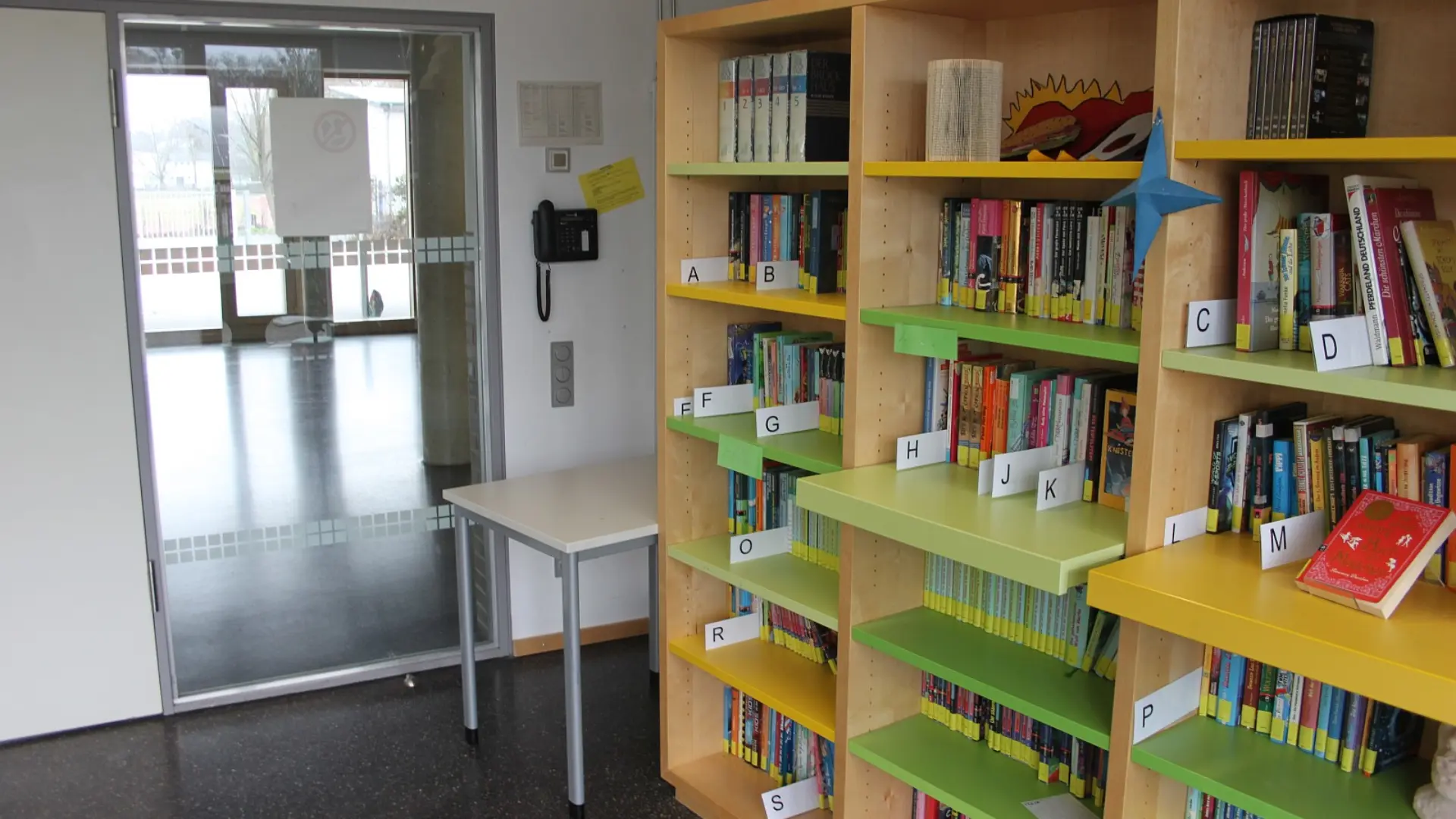 Die gut sortierte Schulbibliothek der Ernst-Jandl-Schule mit farbenfrohen Regalen und einer großen Auswahl an Büchern für die Schüler*innen.